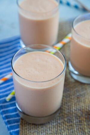 Papaya milkshake poured into three glasses.