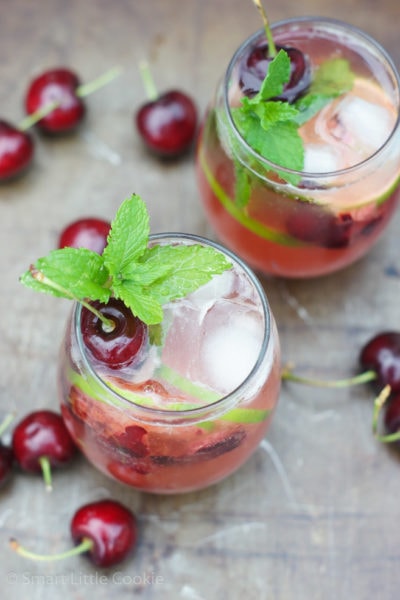 Cherry Mojito served in two glasses with ice and mint sprigs.