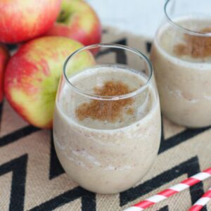 An apple pie smoothie poured into two glasses and topped with cinnamon.