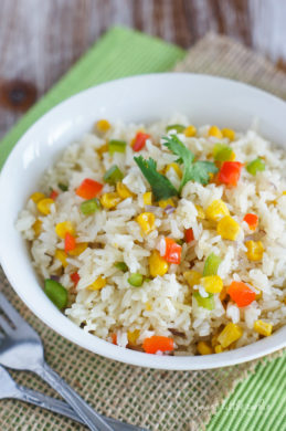 Close up of white rice with corn and peppers.