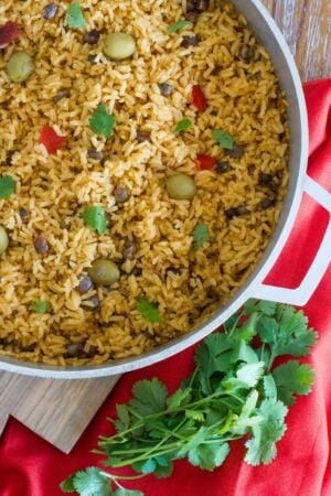 Pigeon peas and rice in a large pot served on a wooden table.