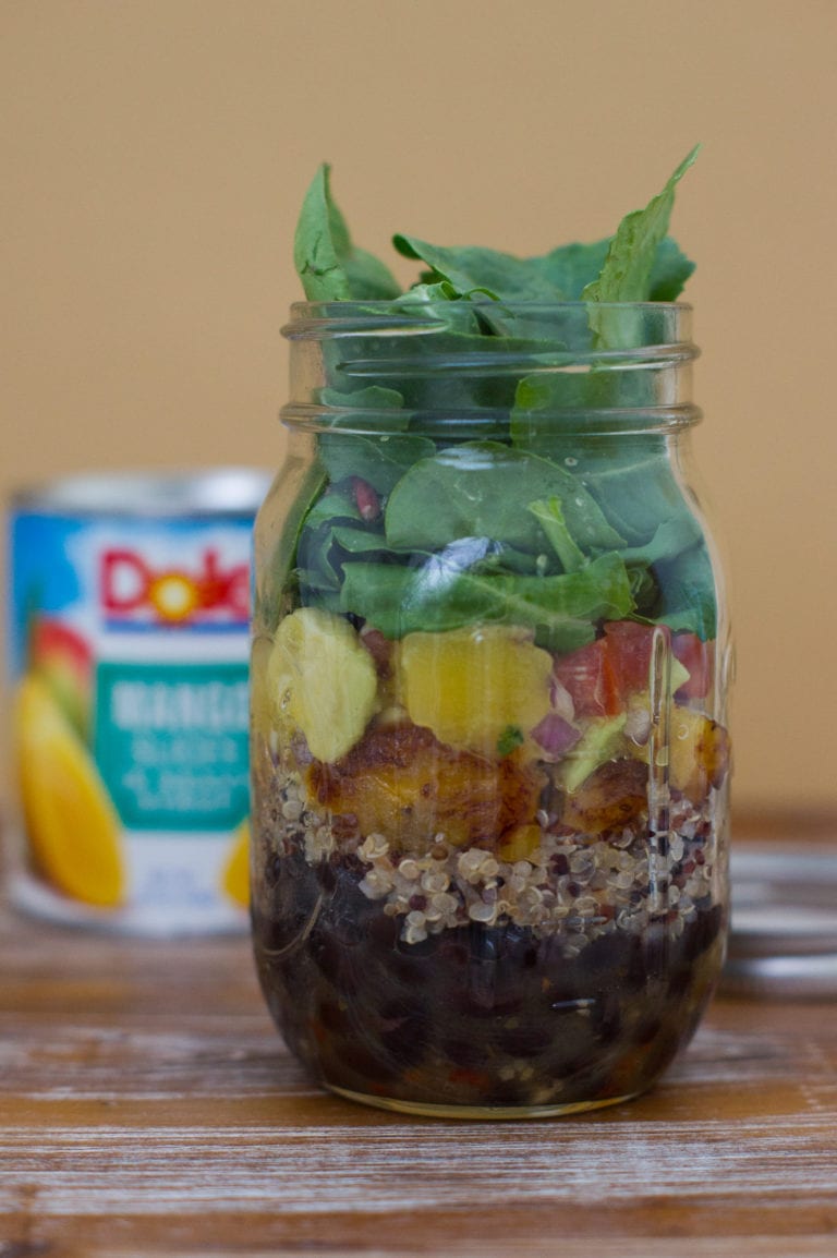 The quinoa salad layered in a glass jar.