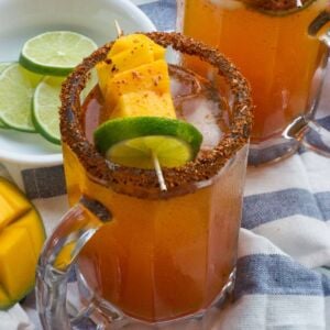 Mango Michelada served in a glass with mango and lime garnish.