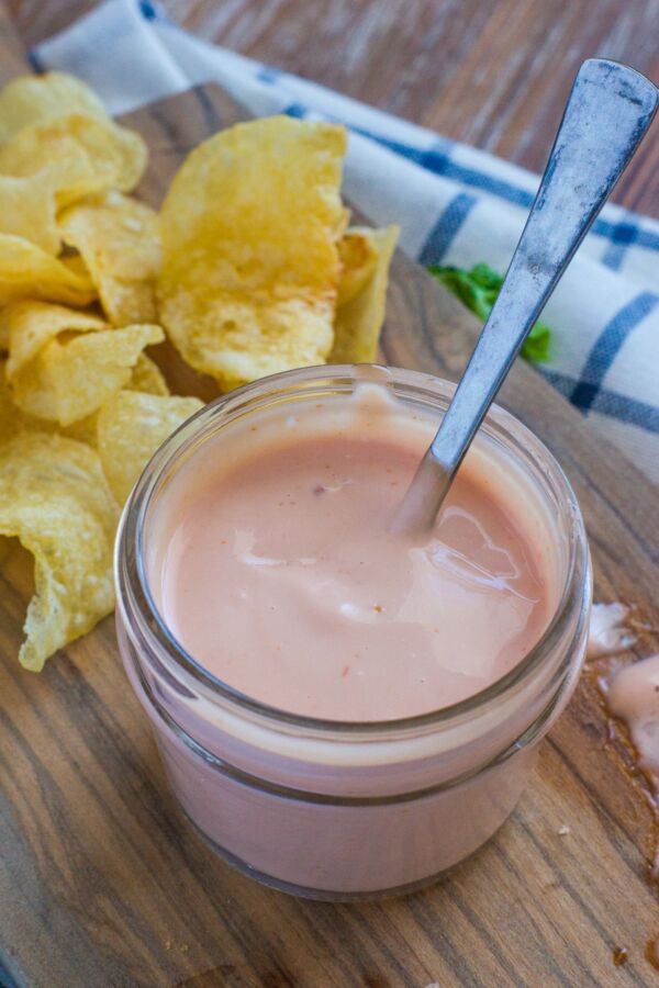 Mayo ketchup sauce in a glass jar with a spoon.