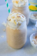Pina colada dulce leche smoothie in a glass mason jar with a straw.
