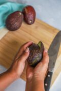 giving avocado a twist to separate in two halves