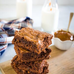 Three dulce de leche brownies stacked on top of each other.