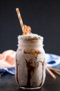 Close up of a milkshake in a mason jar with a straw.