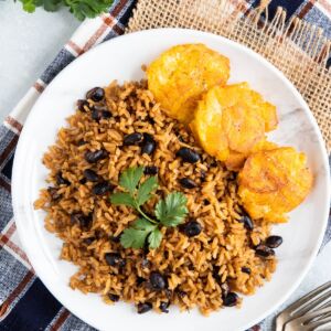 Black beans and rice on a plate garnished with fresh cilantro.