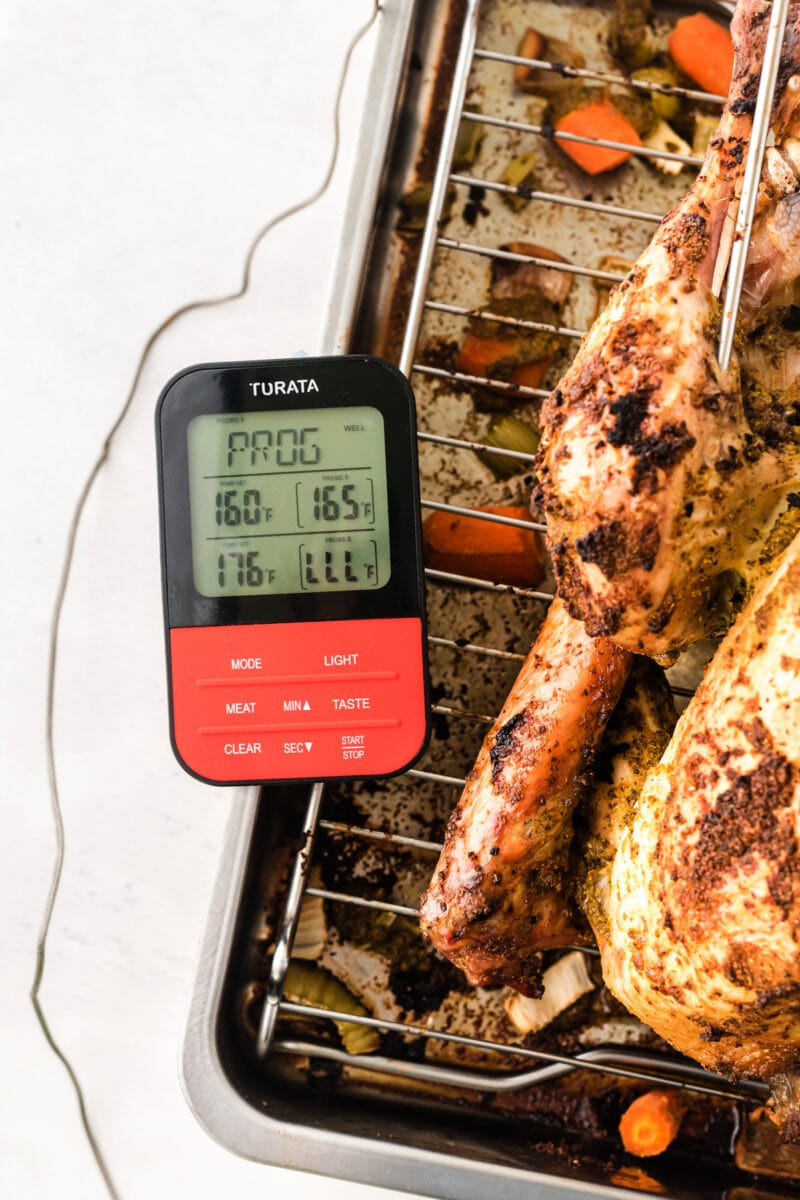 An instant read thermometer testing the temperature of the roasted turkey.