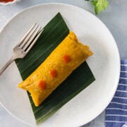 One overhead shot of a pastel en hoja topped with hot sauce
