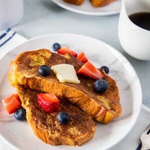 Challah Bread French Toast served on a plate with butter and berries