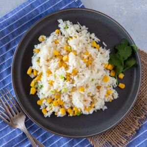 Rice with corn served on a gray plate ready to eat