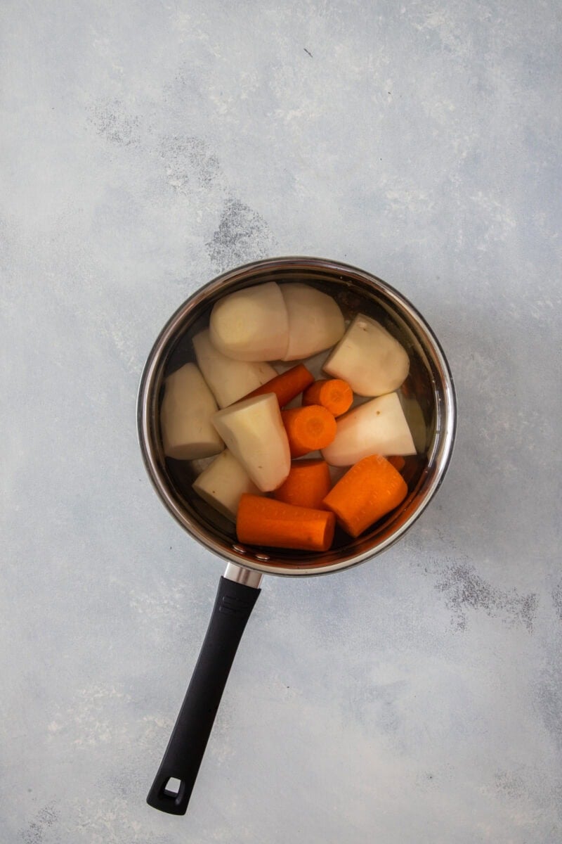 Zanahorias y papas en una olla con agua, listas para hervir.