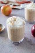 Apple pie smoothie served in a glass and topped with whipped cream