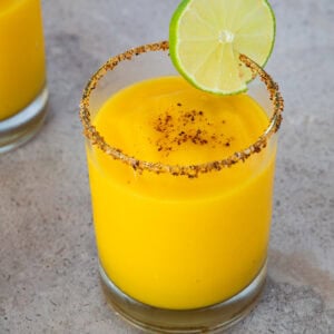 Frozen mango margarita with a chili-salt rim and lime slice garnish.