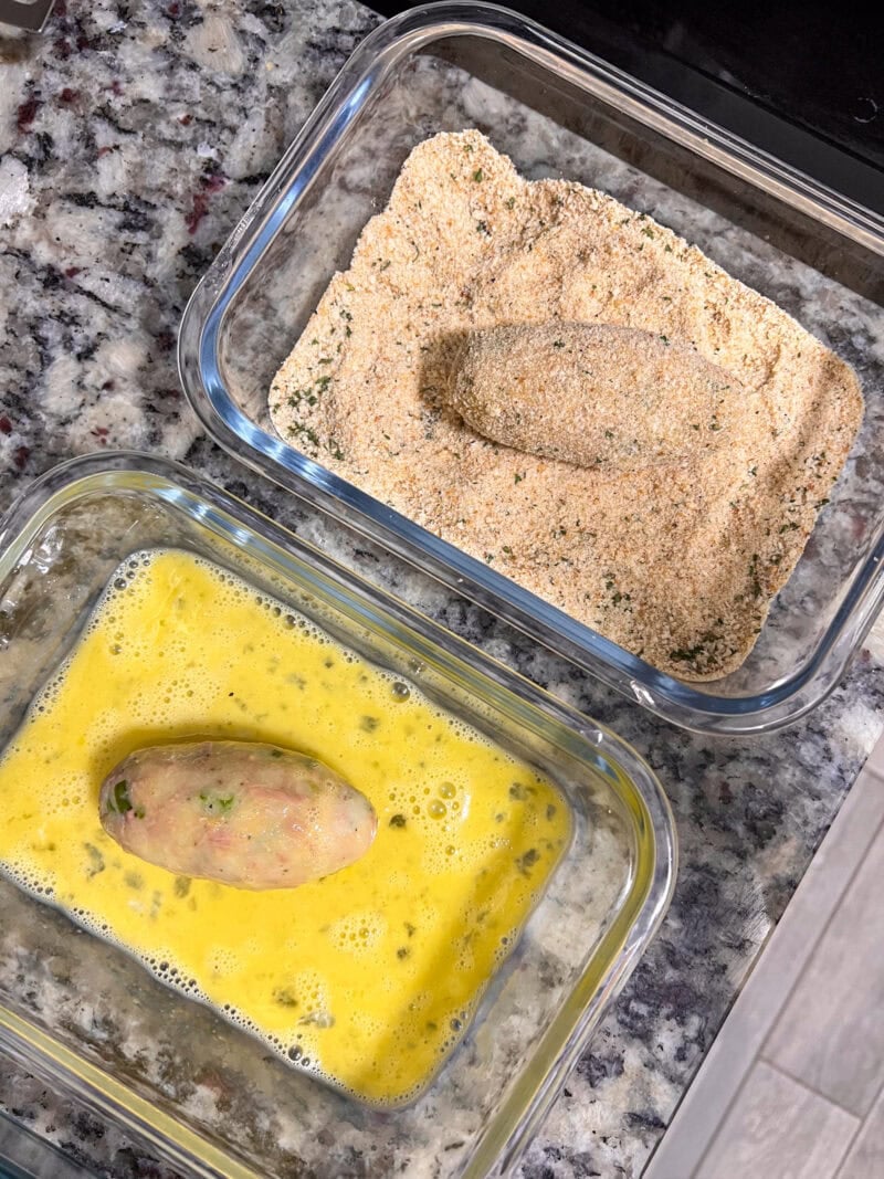 Croqueta rebozada en huevo batido y pan rallado antes de freírla.